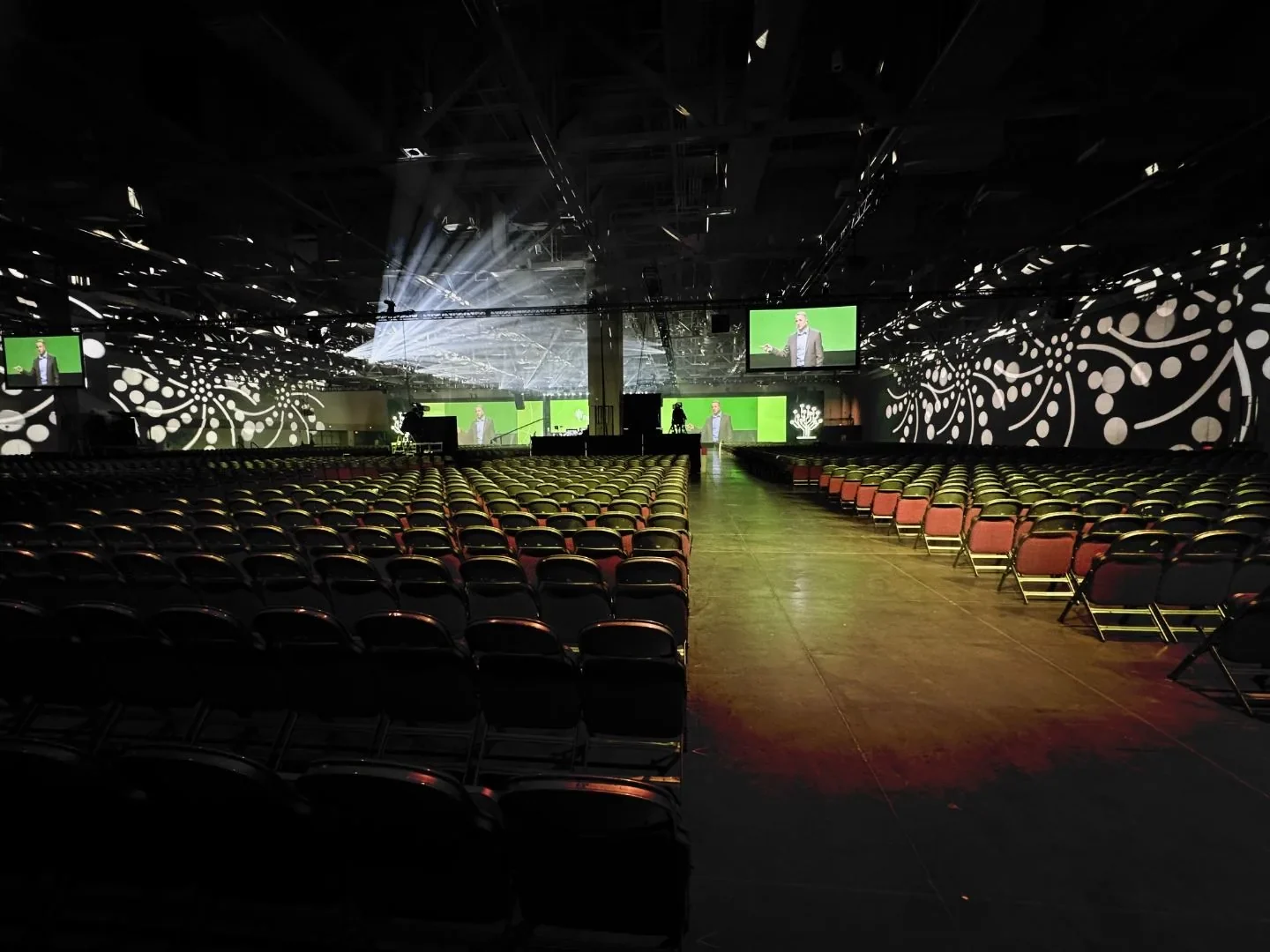 Conference general session in an arena with full-width projection mapping and stage lighting