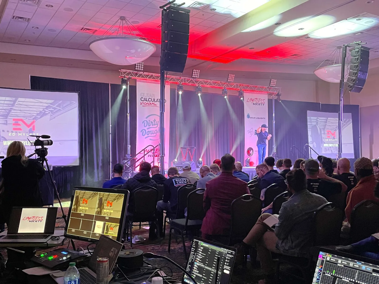 Conference stage with red lighting and screens