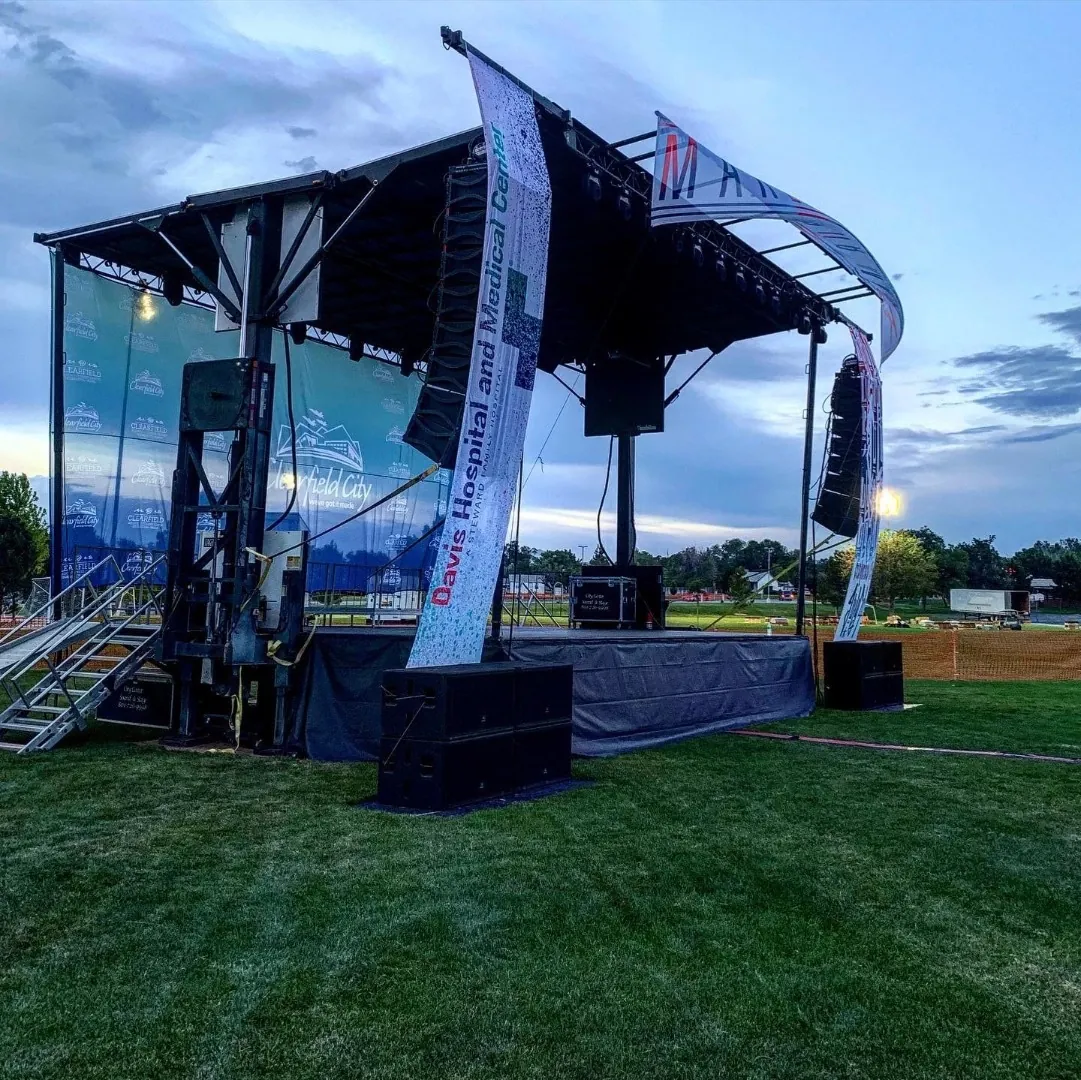 Outdoor mobile stage with line arrays at dusk