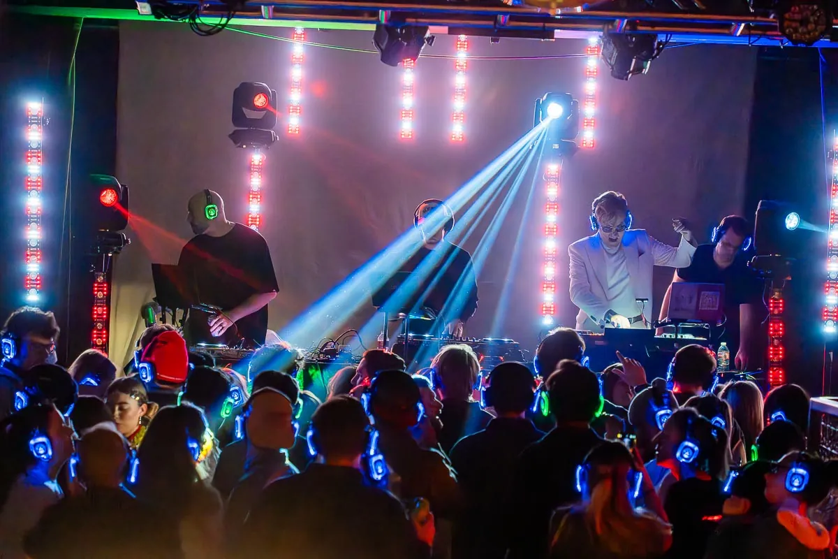Silent disco crowd in glowing wireless headphones