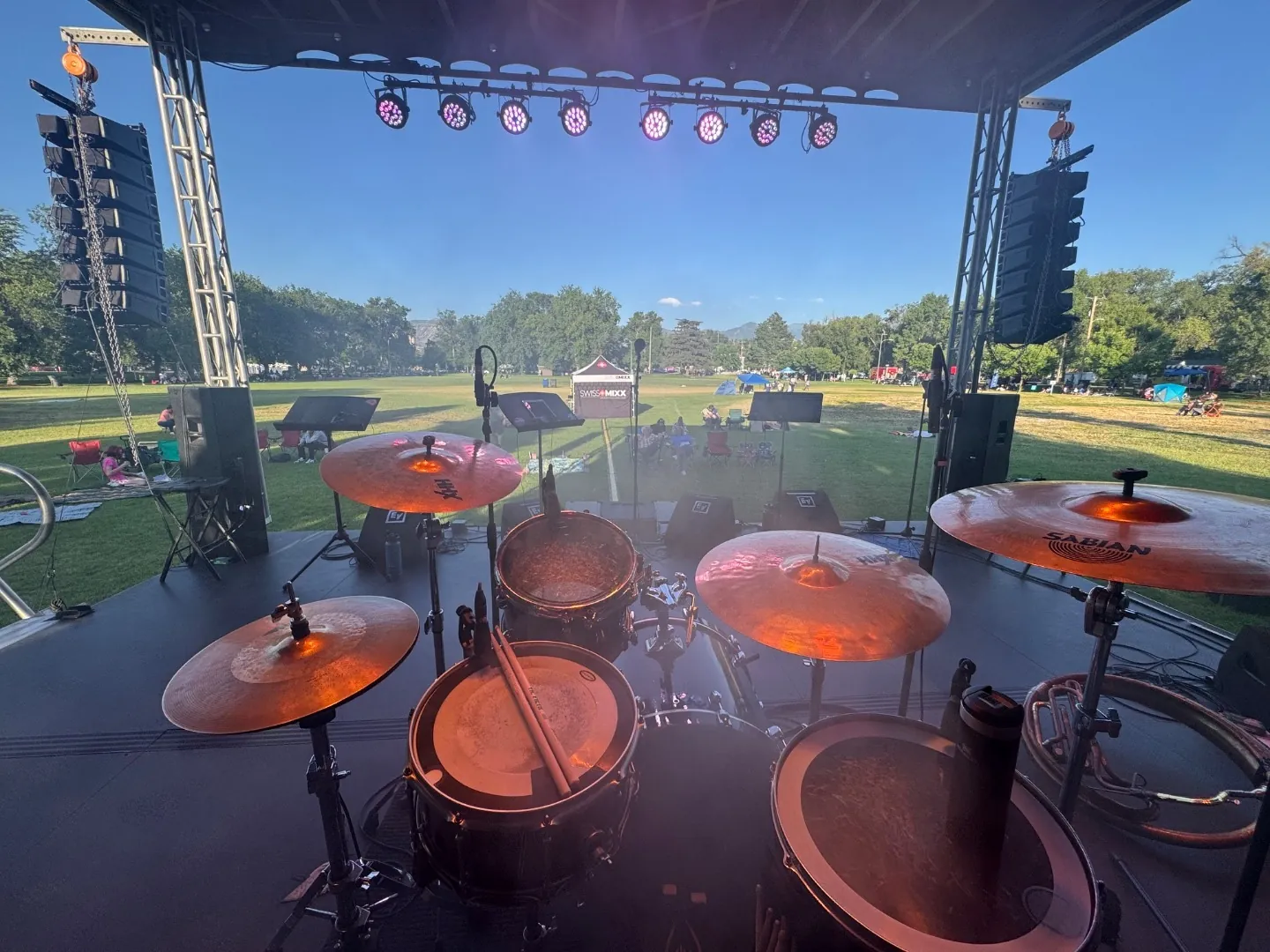 View from behind the drum kit across an outdoor festival stage