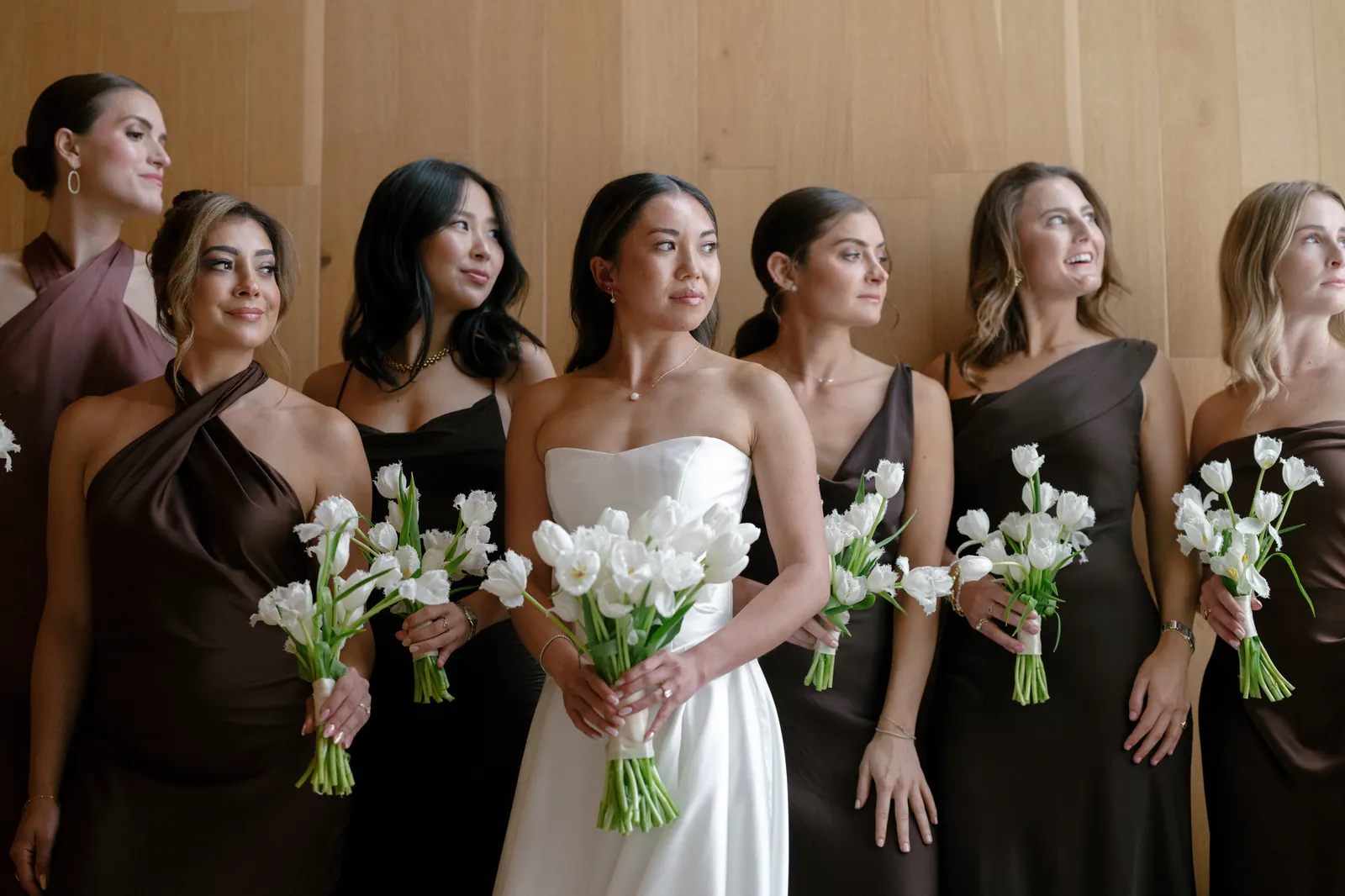 Bridesmaids in brown gowns holding tulip bouquets