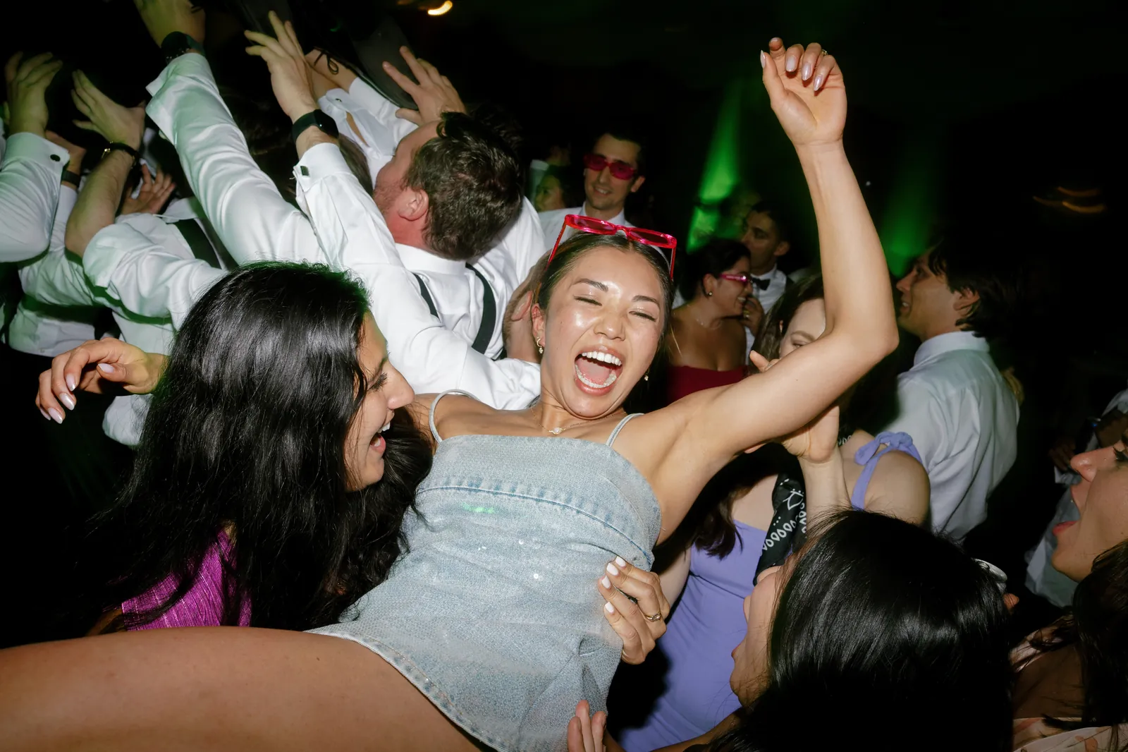 Guests lifting the bride above the dance floor