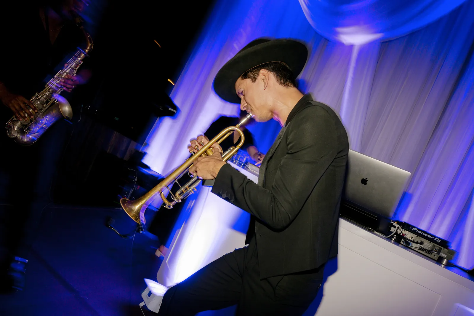 Live trumpet player performing over the DJ set during a wedding dance party