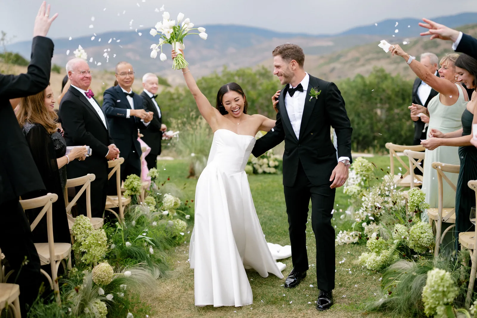 Guests tossing petals over the newlyweds